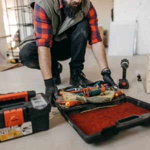 Worker organizing toolbox on floor